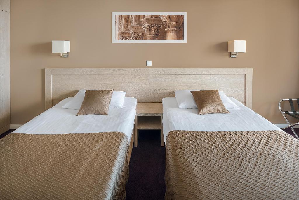 a hotel room with two beds in a room at Hotel Adria in Dubrovnik