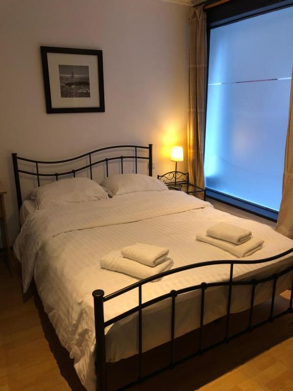ein Schlafzimmer mit einem großen Bett mit zwei Handtüchern darauf in der Unterkunft Hotel Abberdeen in Brüssel