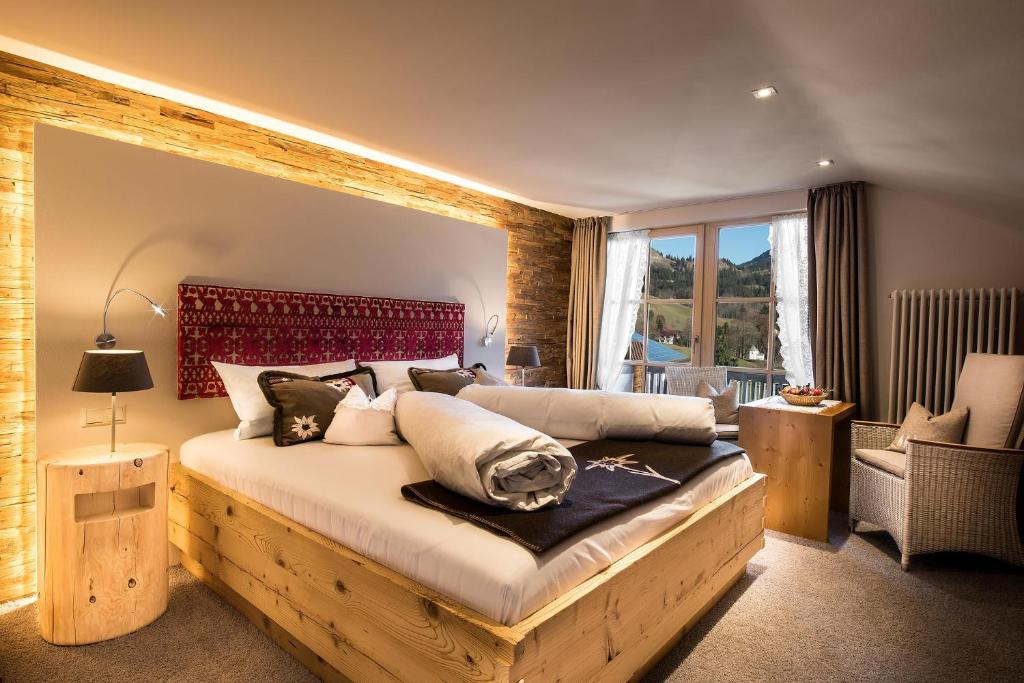 - une chambre avec un grand lit et une tête de lit rouge dans l'établissement Gästehaus Wineberger, à Bad Hindelang