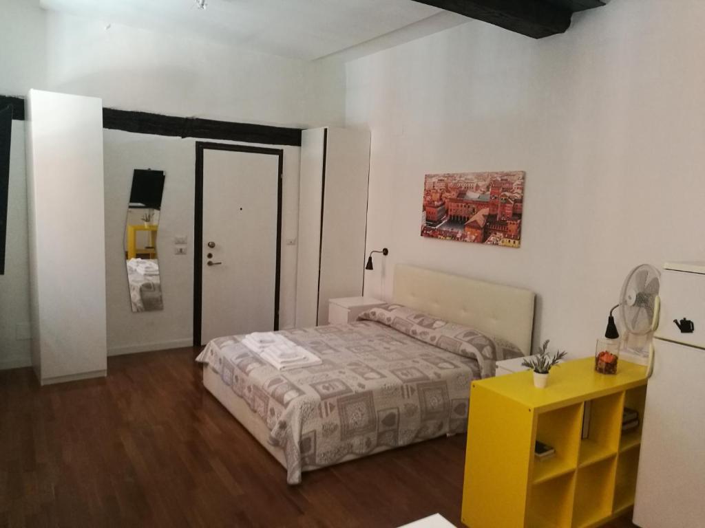 - une chambre avec un lit et une table jaune dans l'établissement Residenza Porta Maggiore, à Bologne