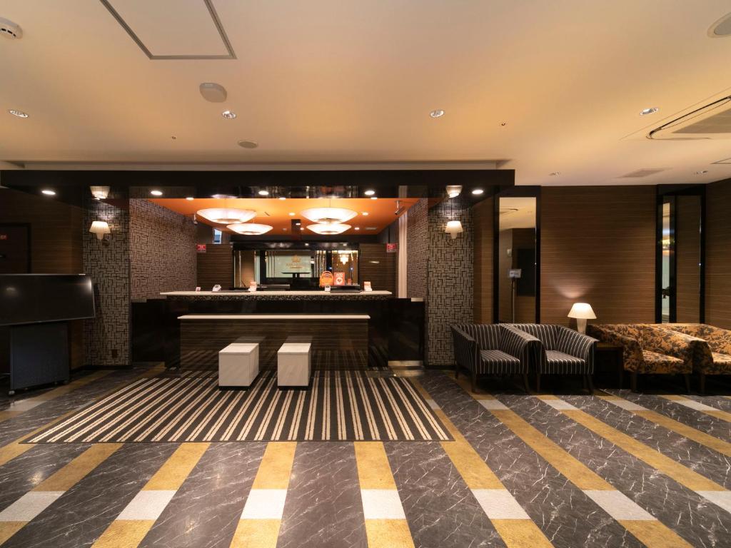 姫路市にあるアパホテル 姫路駅北のホテルのロビーにはバーと椅子があります。