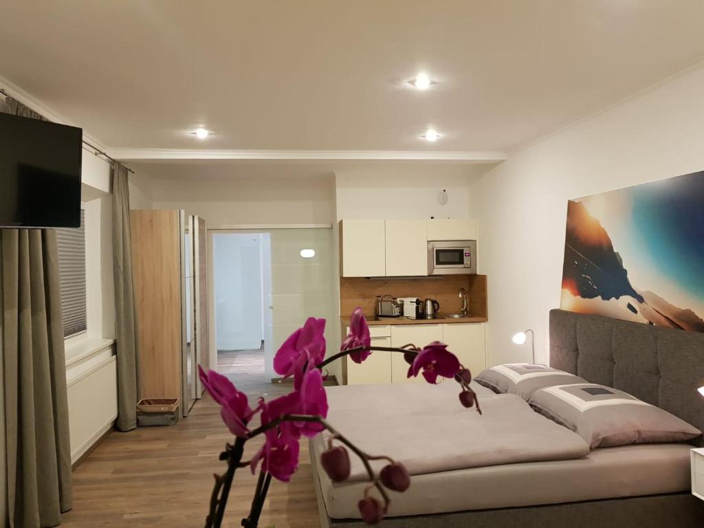 un soggiorno con divano e fiori rosa di Echt Heimat Apartments a Sankt Gilgen