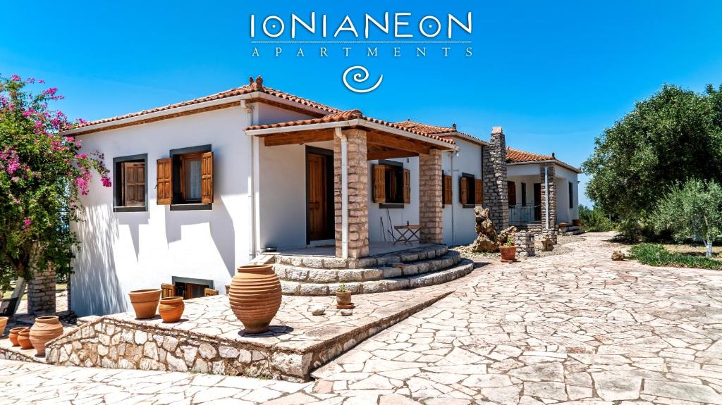 IONIANEON APARTMENTS في Áyios Ilías: منزل أمامه ممر حجري