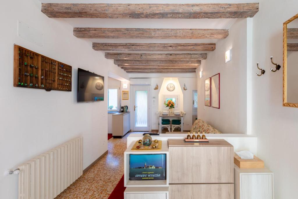 a living room with white walls and a ceiling with wooden beams at Ca' Marcello - BIENNALE in Venice