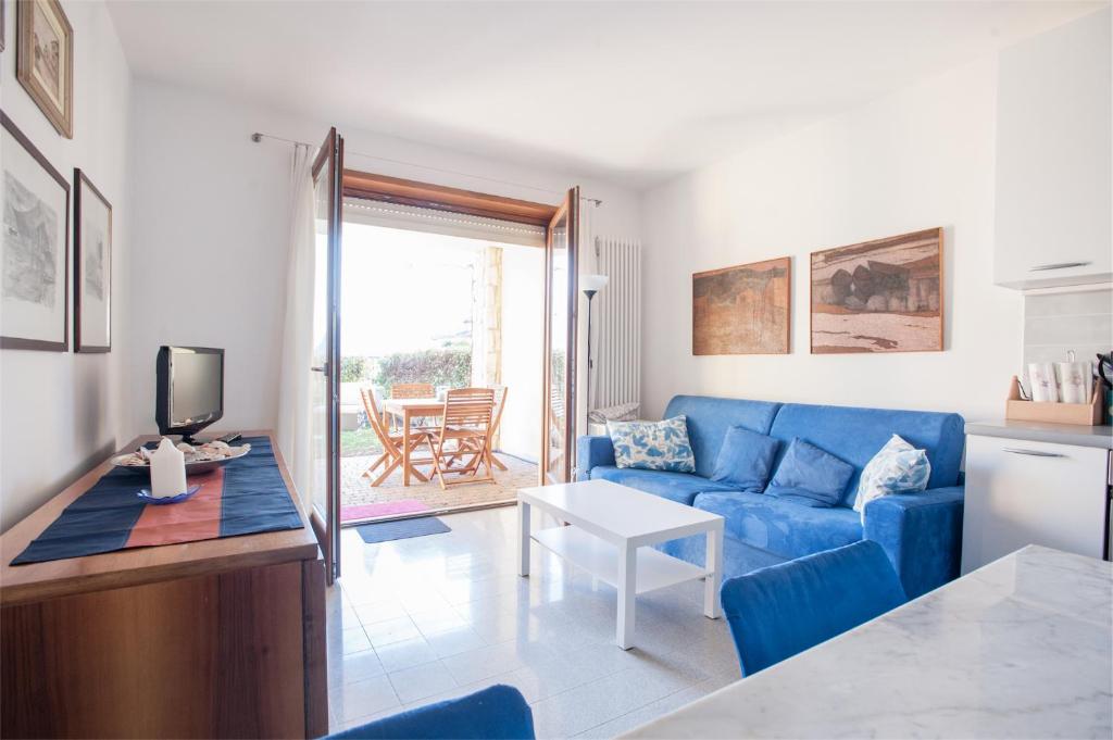 een woonkamer met een blauwe bank en een tafel bij Casa Davide in Riva del Garda