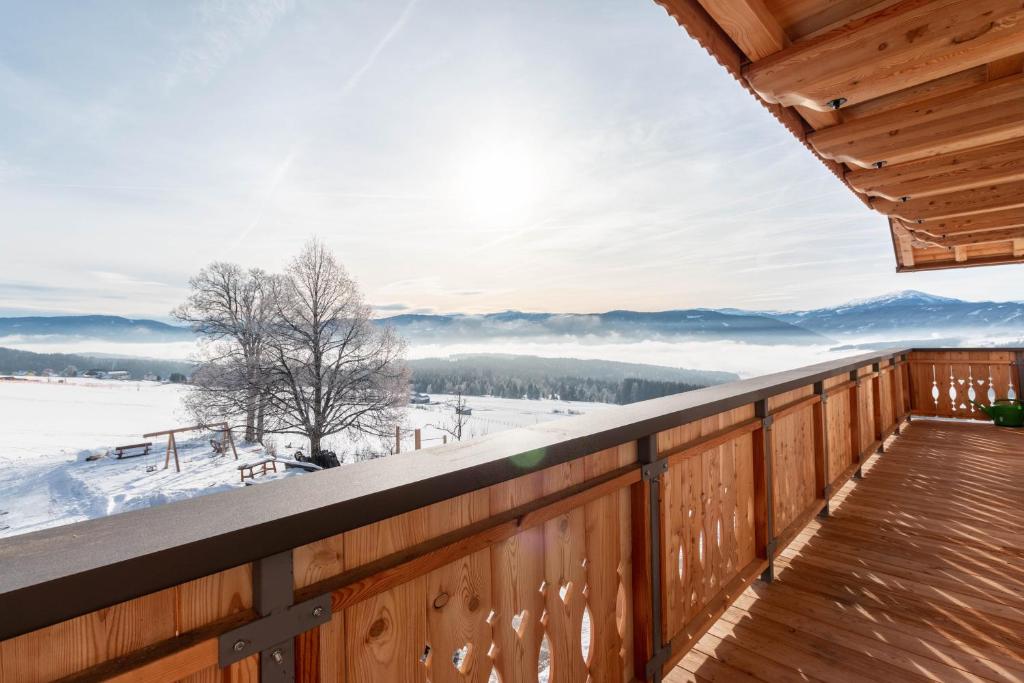 a deck with a view of the snow covered mountains at Schlicknhof in Mariapfarr