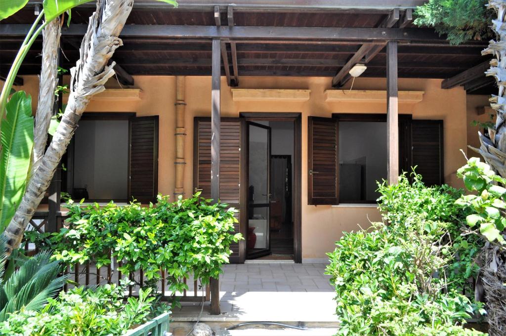 an entrance to a house with trees and plants at Casa Mia 6 posti letto con giardino in San Vito lo Capo