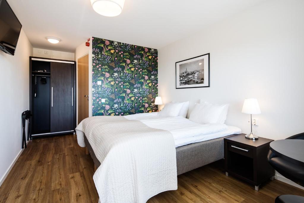 une chambre d'hôtel avec un lit et un tableau sur le mur dans l'établissement Villa Solviken, à Lysekil