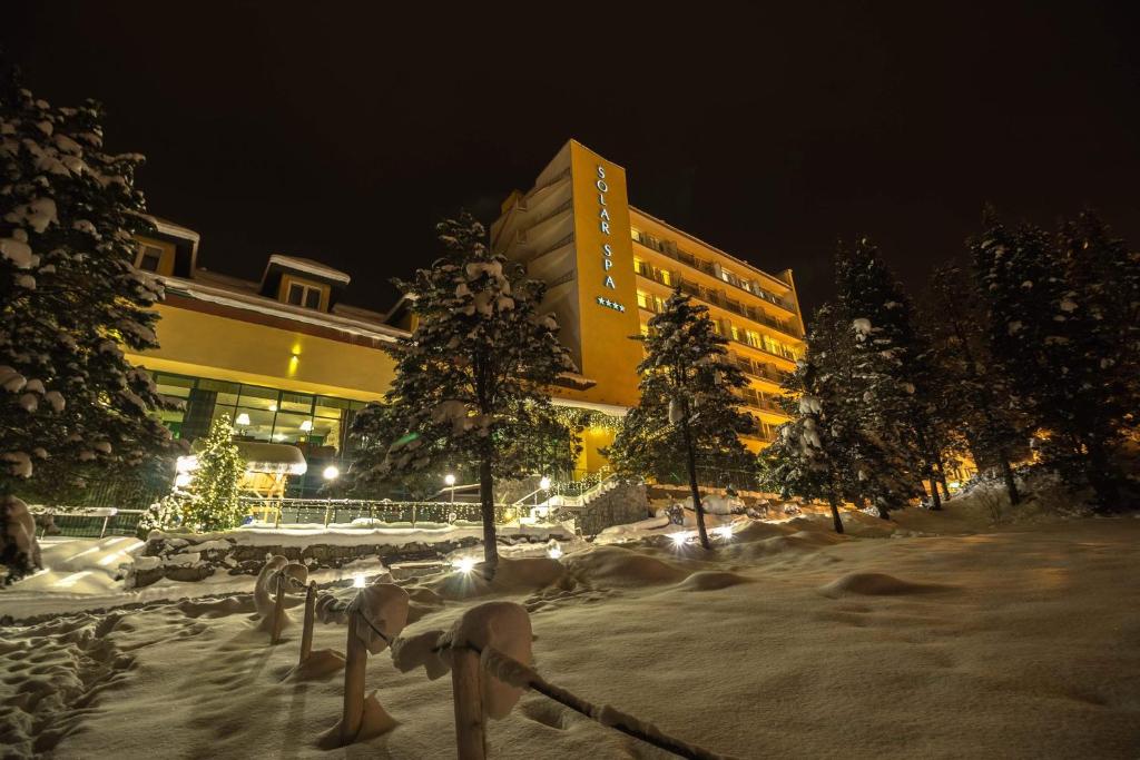 a building at night with snow on the ground at Hotel Solar in Szczawnica
