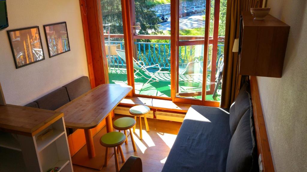 a living room with a table and a window at Le Vogel in Arc 1800