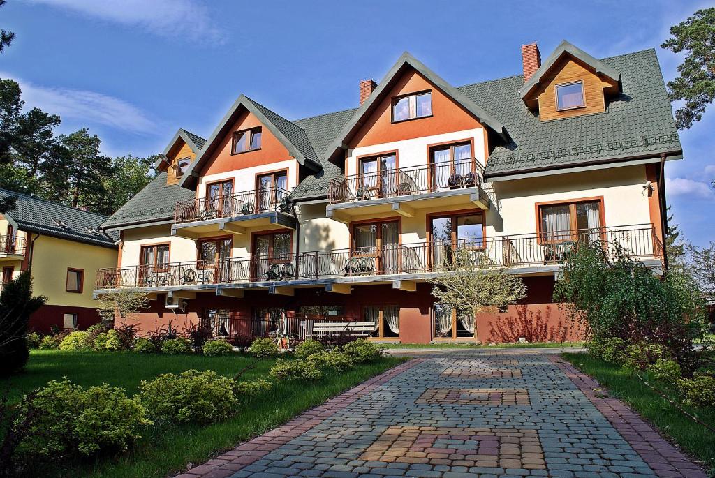 Charming multi-story guesthouse with balconies, surrounded by lush greenery.