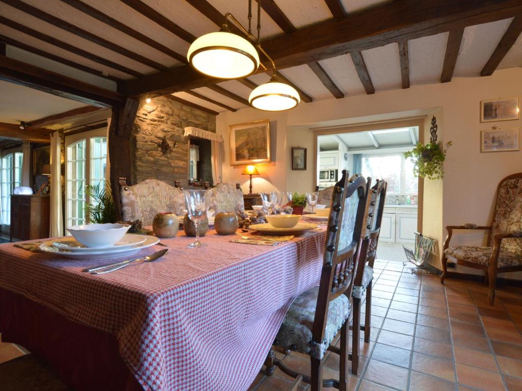 een eetkamer met een tafel met een tafelkleed bij Cozy Cottage in Malmedy with Large Garden in Malmedy