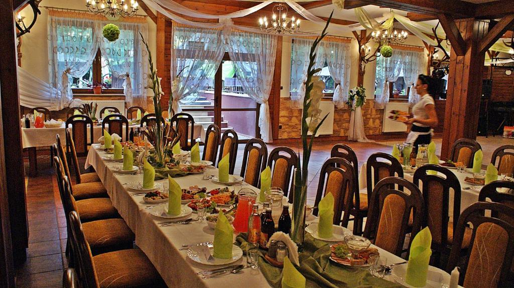 Elegant dining room with long table, green napkins, and decorative lighting.