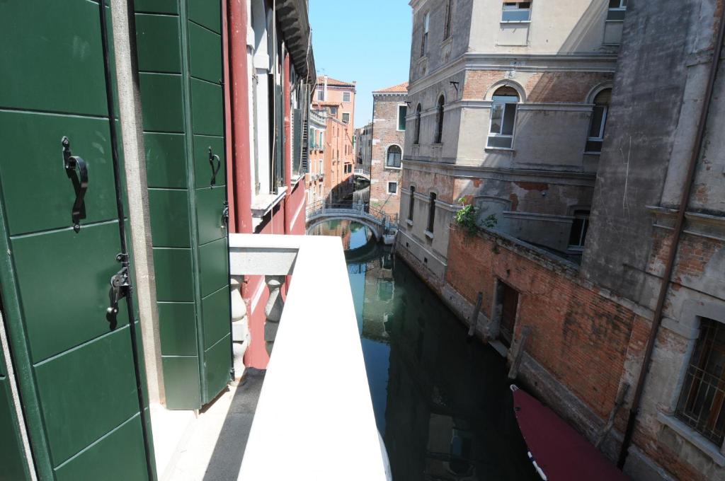 einen Balkon mit Blick auf einen Kanal in einer Stadt in der Unterkunft Sunny Canal a/c wifi in Venedig