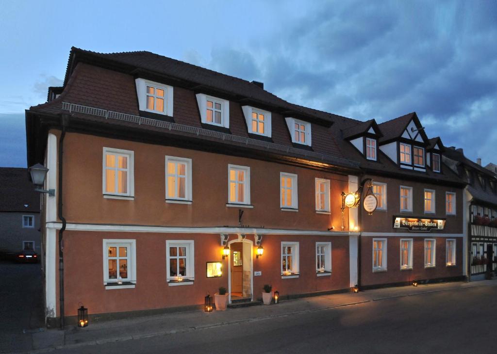 ein großes braunes Gebäude mit weißen Fenstern auf einer Straße in der Unterkunft Le Anfore in Bad Windsheim