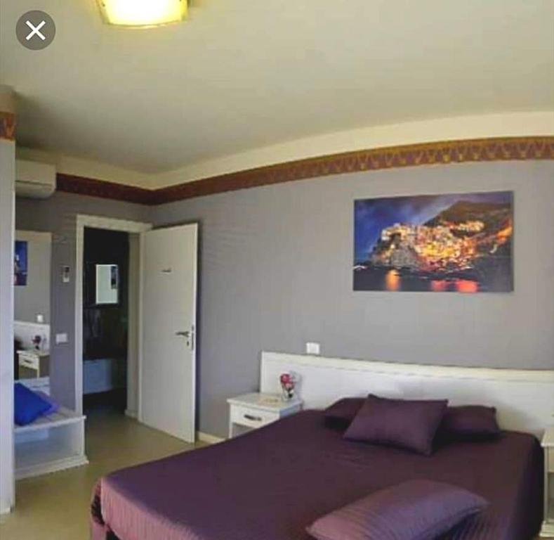 una camera da letto con un grande letto con una coperta viola di B&B La Sicilia a Tavola a Pisa