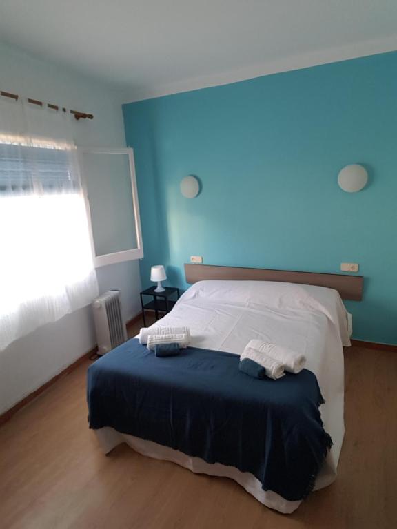 a bedroom with a bed with a blue wall at Hostal Pancheta in San Pol de Mar