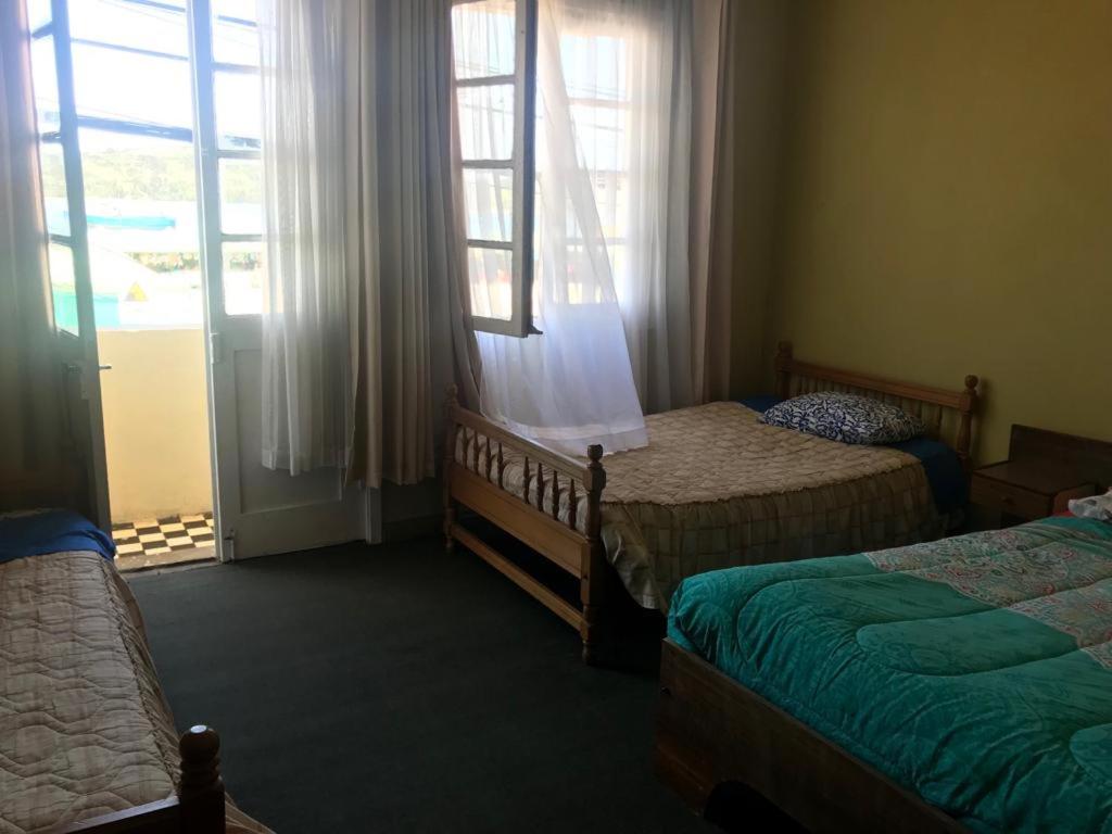 1 dormitorio con 2 camas y ventana en Hospedaje Vista al Mar 39, en Castro