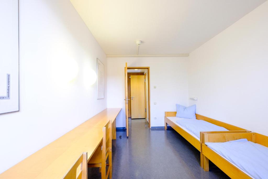 Postel nebo postele na pokoji v ubytování Internationales Jugendgästehaus Dachau