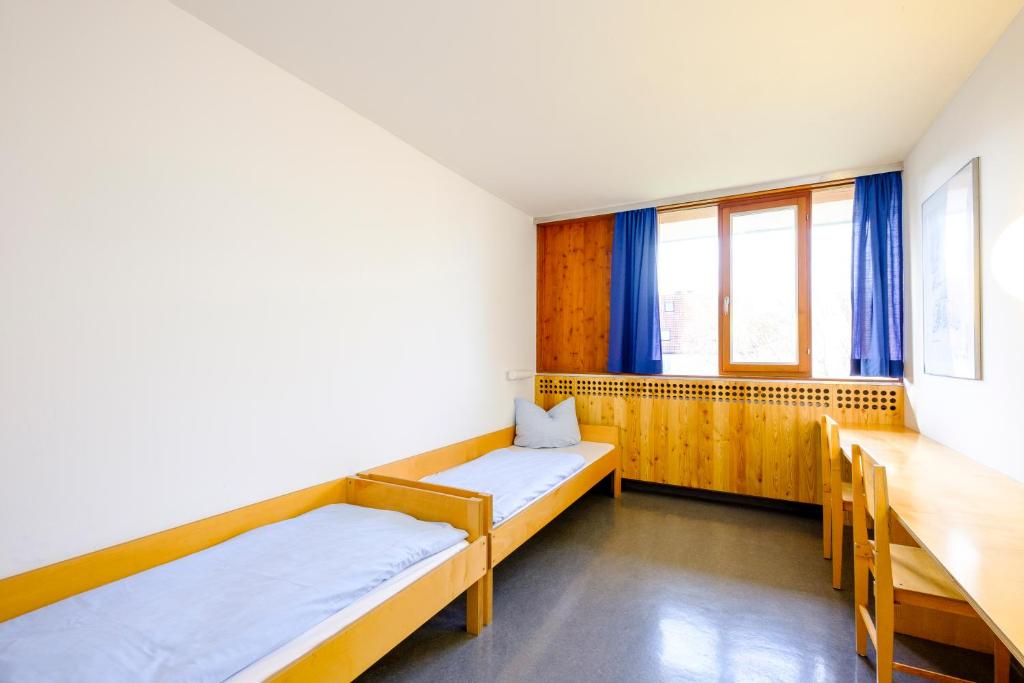 Postel nebo postele na pokoji v ubytování Internationales Jugendgästehaus Dachau