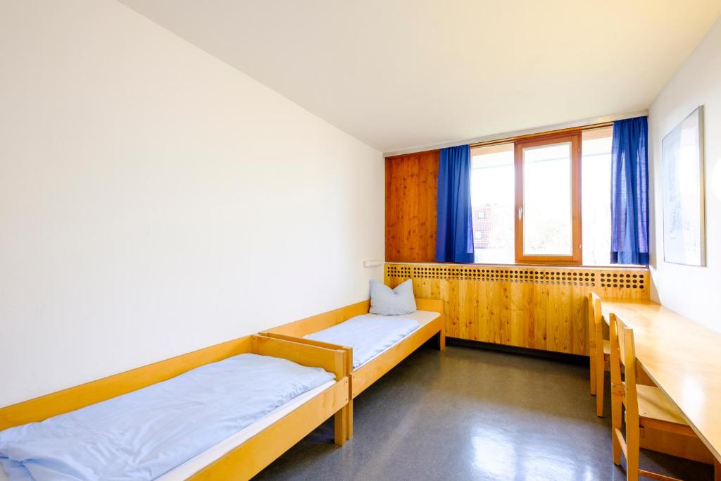 Postel nebo postele na pokoji v ubytování Internationales Jugendgästehaus Dachau