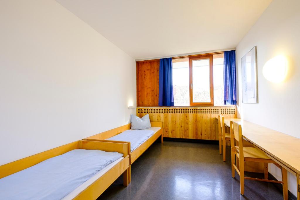 Postel nebo postele na pokoji v ubytování Internationales Jugendgästehaus Dachau