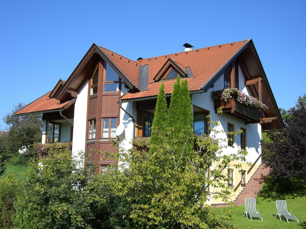 una grande casa con tetto rosso di Appartement Haus Drobollach a Drobollach am Faakersee