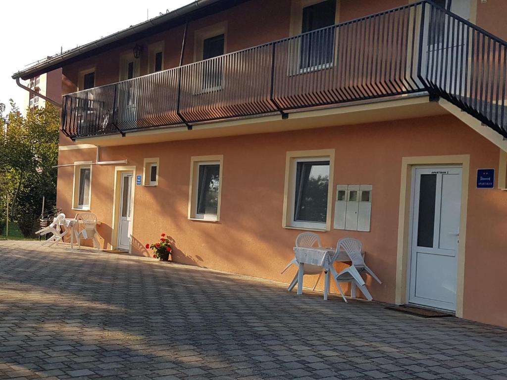 a building with a balcony and chairs in front of it at Apartments Martina in Osijek