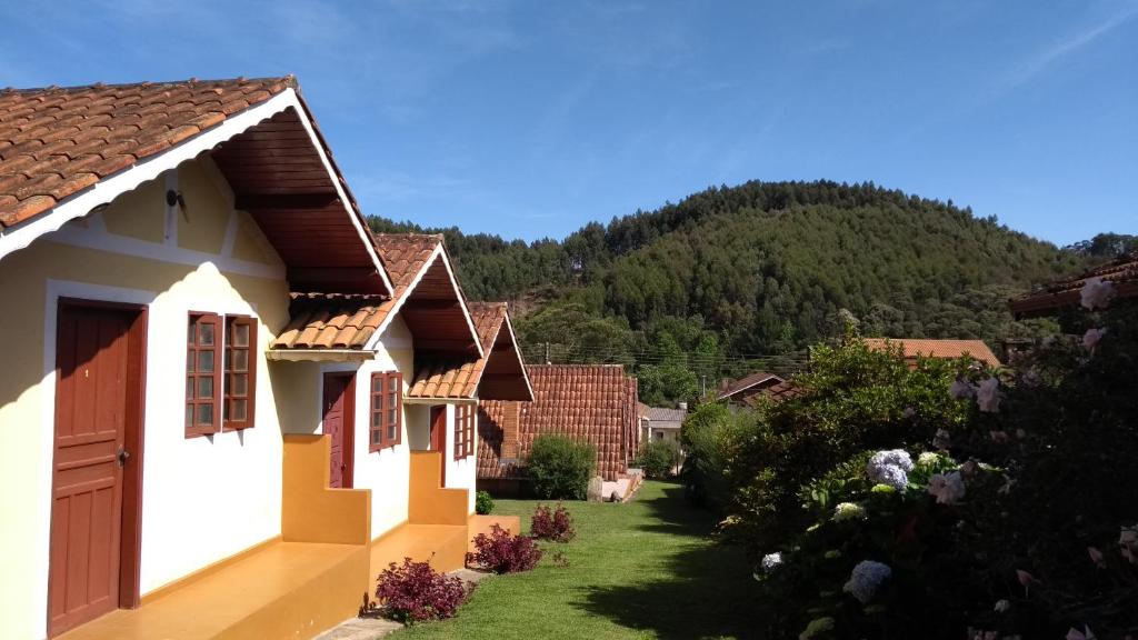 a view of a house with a mountain in the background at Pousada Borogan in Monte Verde