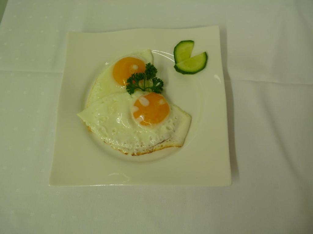 a white plate with an egg and avocado on it at Cafe und Pension Blohm in Greifswald