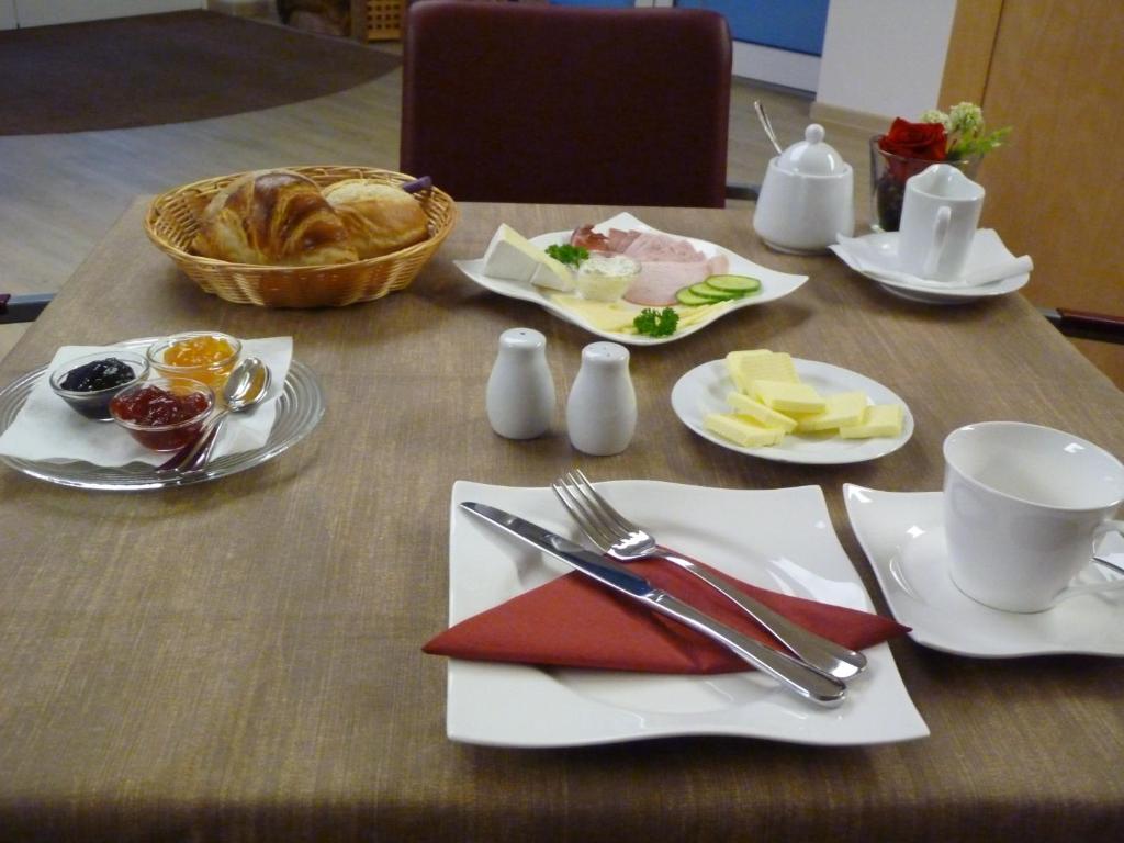 a table with plates of food and a basket of food at Cafe und Pension Blohm in Greifswald