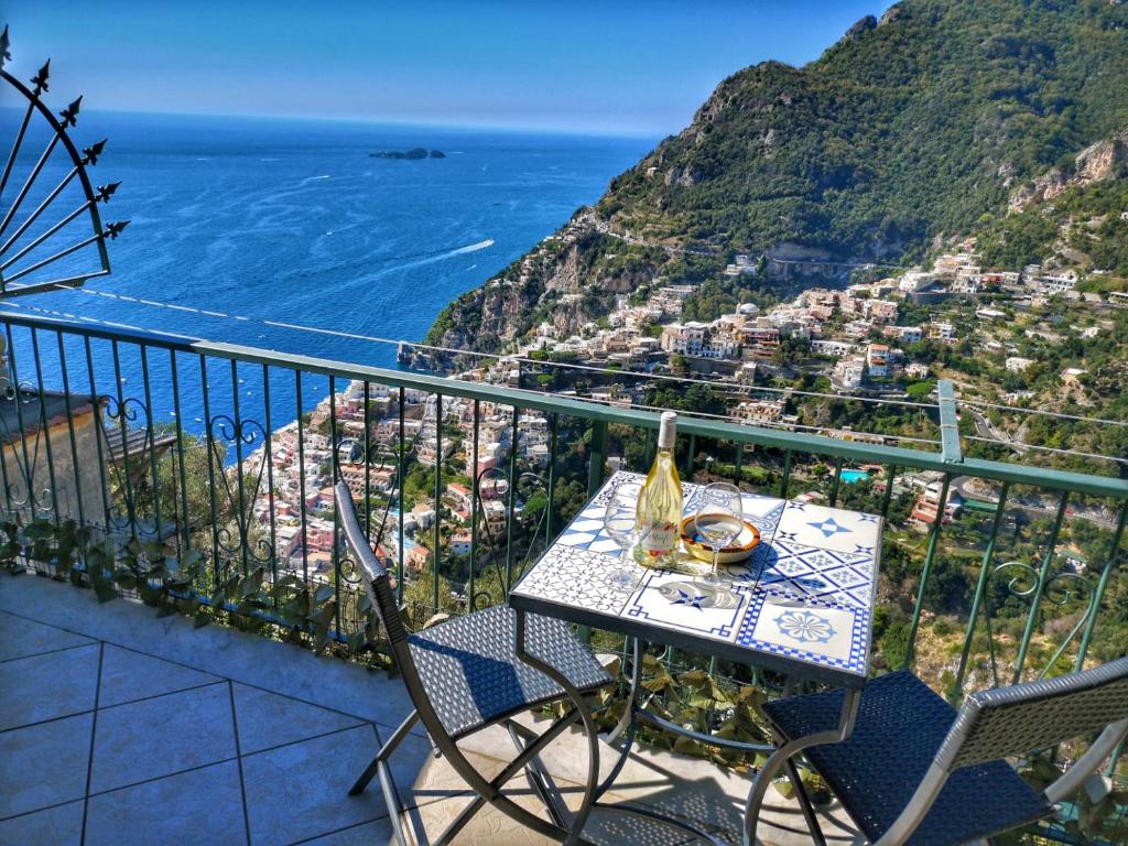 un tavolo e sedie su un balcone con vista sull'oceano di Casa TerryB - il Monticello a Positano