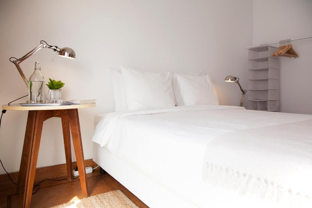 a bedroom with a bed and a table with a lamp at Alface Room in Lisbon