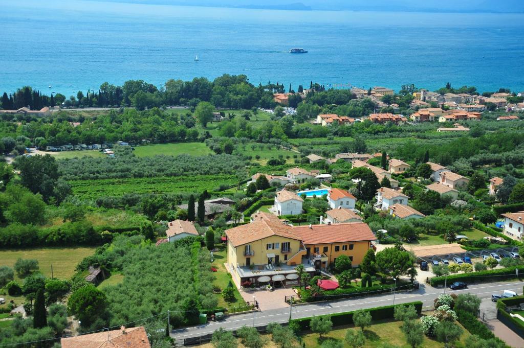z góry widok na wioskę z domem i oceanem w obiekcie Albergo Panoramica w mieście Bardolino