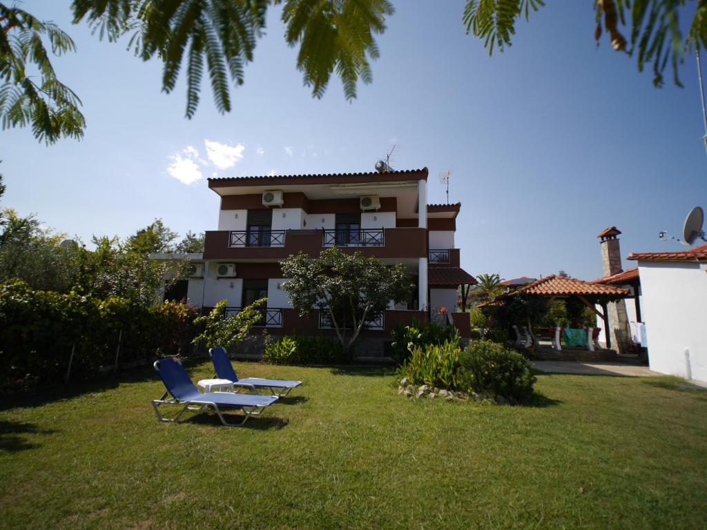 a house with two chairs and a table in the yard at Lampos House Vourvourou in Vourvourou