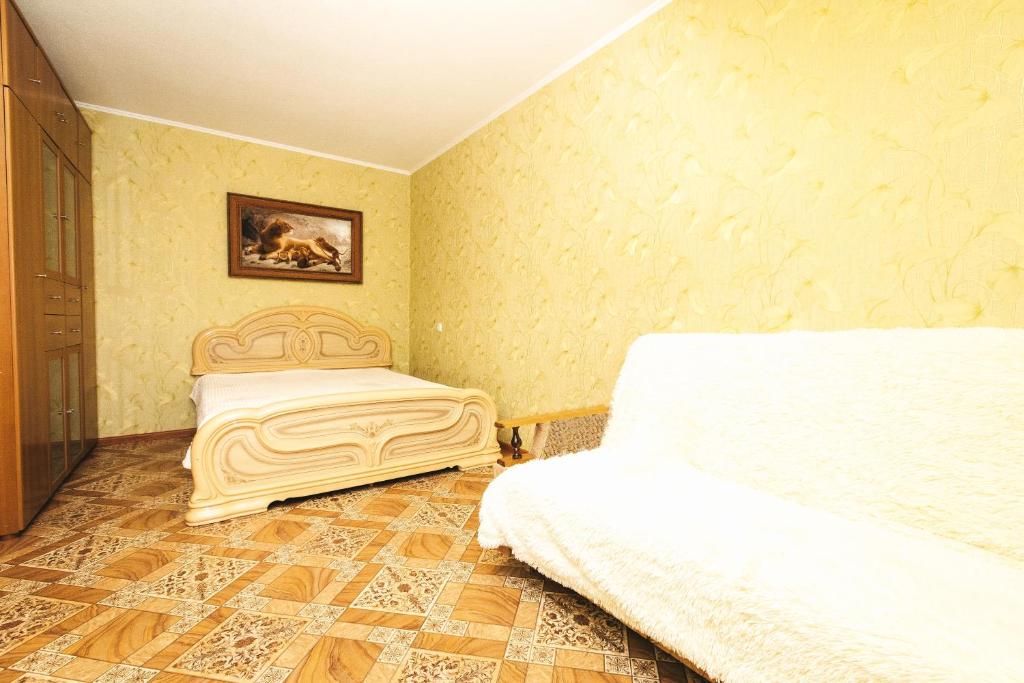 ニジニ・ノヴゴロドにあるHomeHotel Комсомольская 13のベッドルーム1室(ベッド1台付)が備わります。壁には絵画が飾られています。