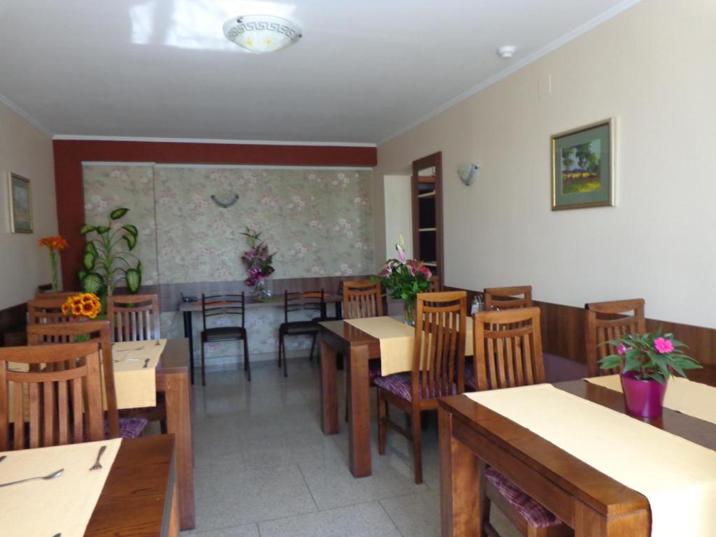 un comedor con mesas y sillas y una pizarra en Hotel Lyra, en Oradea
