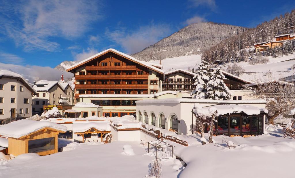 a lodge in the snow with snow covered buildings at Beauty & Wellness Hotel Tirolerhof in Nauders