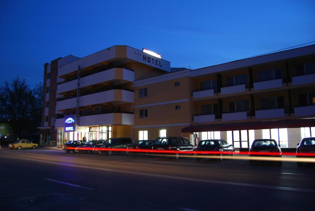 a building with cars parked in front of it at Hotel Europolis in Tulcea