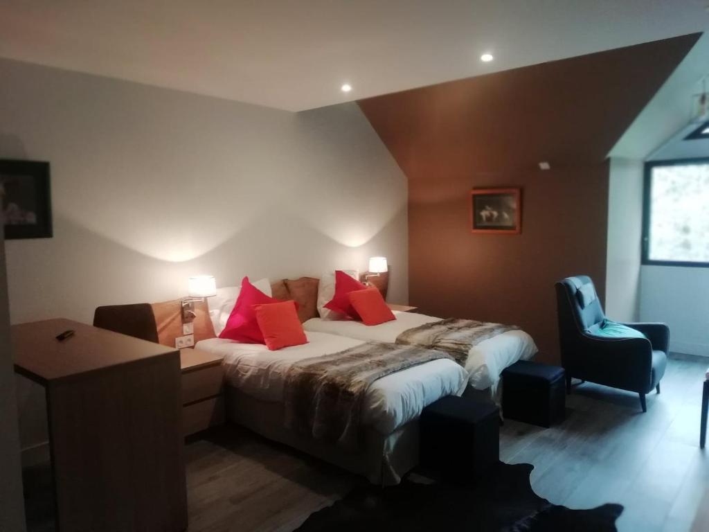 Un dormitorio con una cama con almohadas rojas y una silla en Casa Mir en Saint-Lary-Soulan