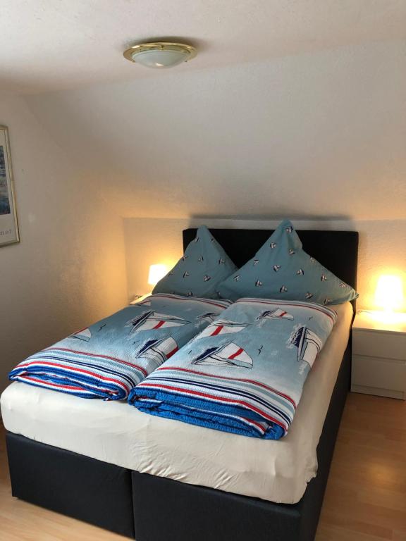 a bedroom with a bed with blue sheets and pillows at Gästehaus Ziemons in Cochem