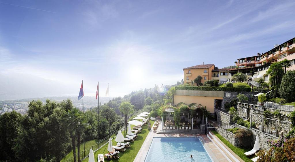 a beach with a pool and a balcony overlooking the ocean at Villa Orselina - Small Luxury Hotel in Locarno