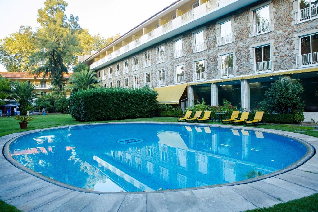 a large swimming pool in front of a building at Hotel Grao Vasco in Viseu