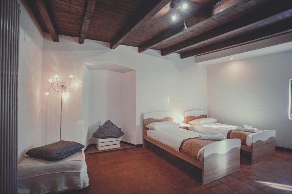 - une chambre avec 2 lits et un banc dans l'établissement Divino Suite 2.0, à Bergame