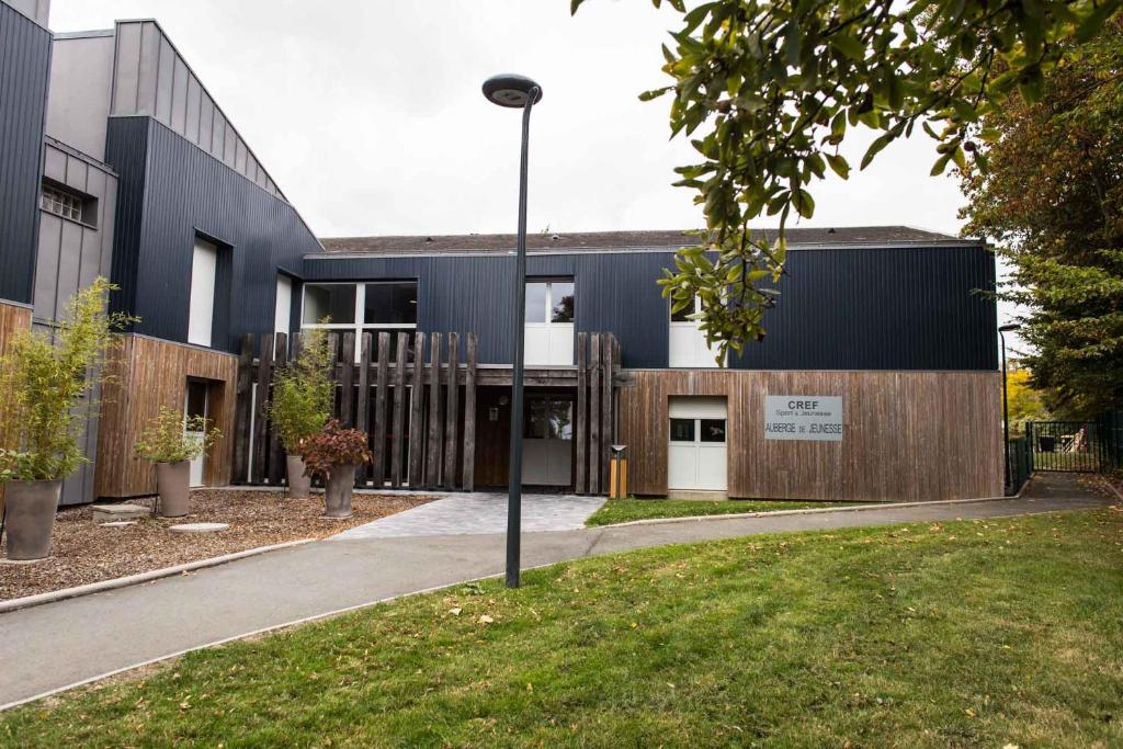 un bâtiment noir avec un éclairage de rue devant lui dans l'établissement Centre International de Séjour, à Laval