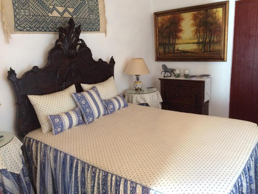 a bedroom with a large bed with blue and white sheets at Quarto Monte Ninho das Perdizes in Cercal