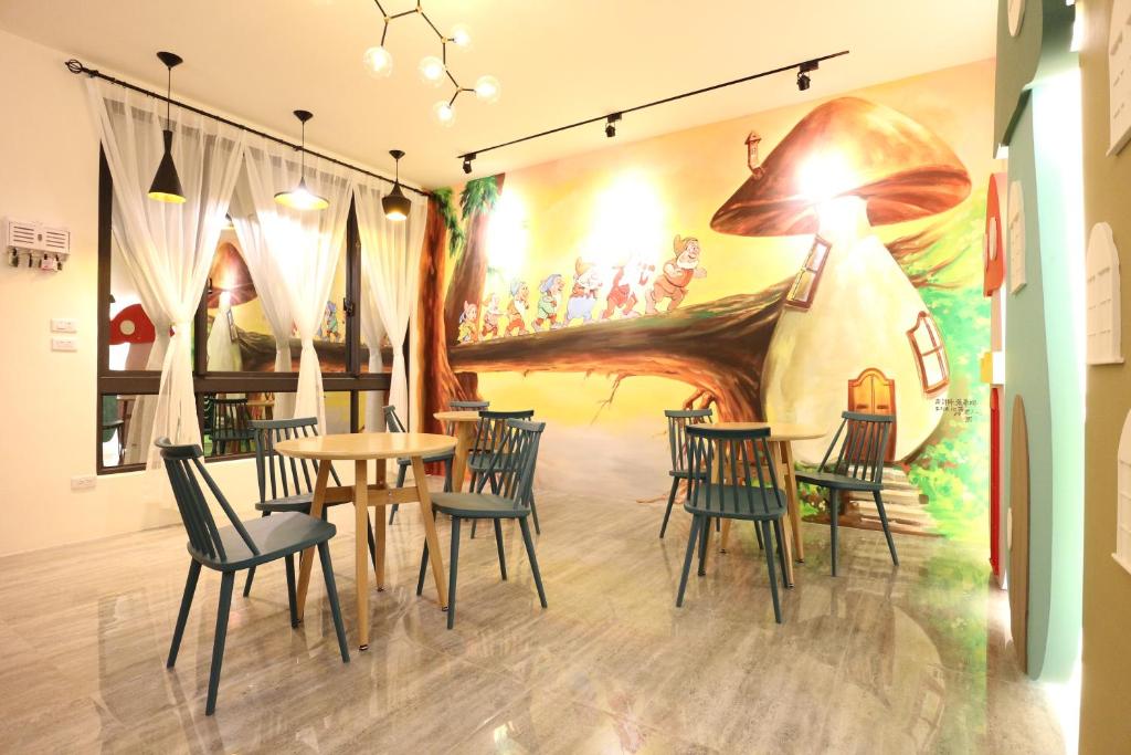 een kamer met stoelen en een tafel en een muurschildering bij 蘑菇城堡民宿 in Taitung