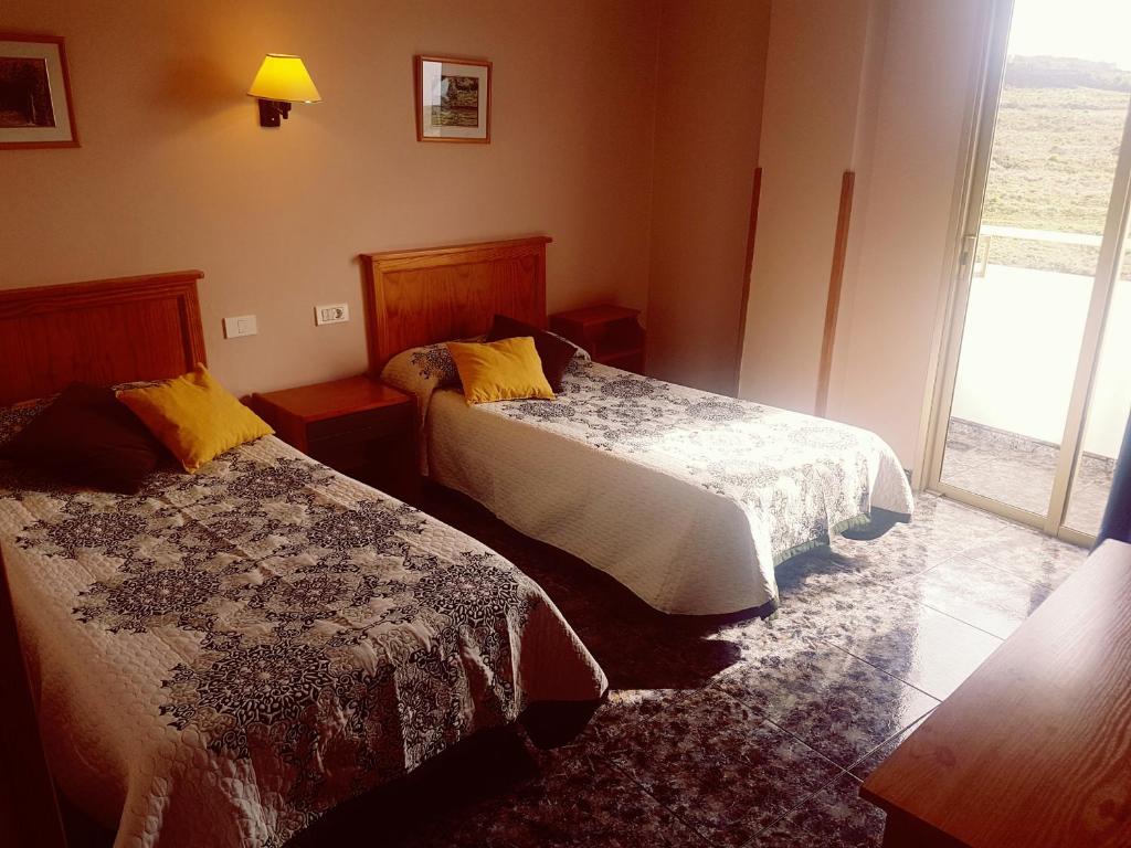 a hotel room with two beds and a window at Hotel Sonia Chipude in El Cercado
