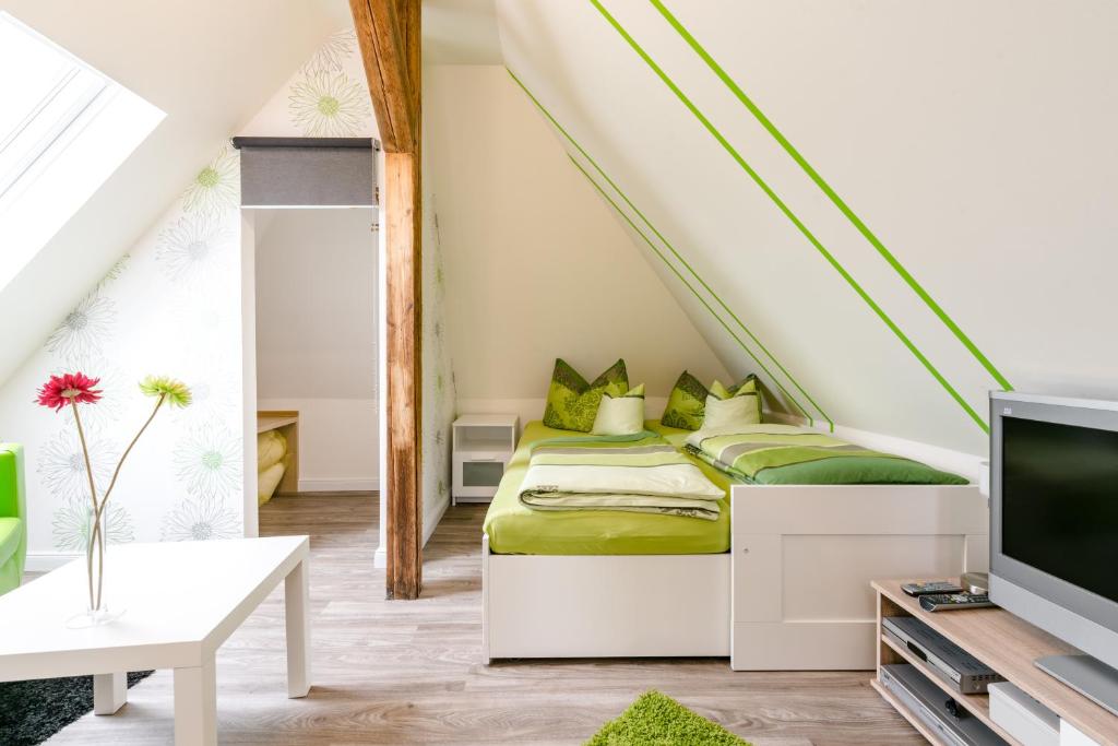 a bedroom with a bed with green sheets and a tv at Ferienwohnung Franke in Heilbad Heiligenstadt