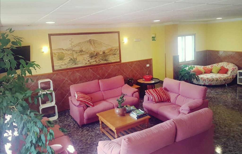 a living room with pink couches and a table at Hotel Sonia Chipude in El Cercado